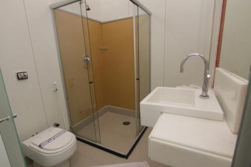 uma casa de banho com um chuveiro, um WC e um lavatório. em Raru's Motel Cidade Jardim (Adult Only) em Natal