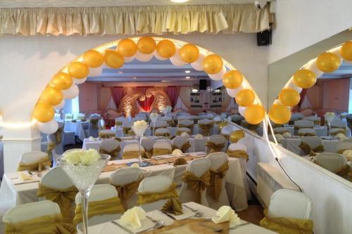 een feestzaal met tafels en stoelen en een ballonboog bij Star Hotel, South Leicester in Leicester