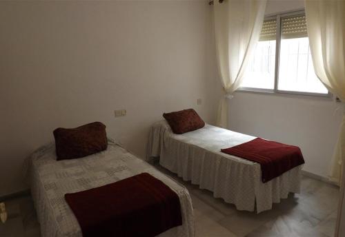 2 letti in una camera con finestra di Apartment in Miramar Fuengirola I a Fuengirola