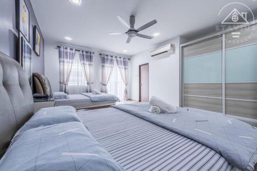 a bedroom with two beds and a ceiling fan at Happy Villa Homestay in Port Dickson
