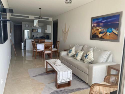 a living room and kitchen with a couch and a table at Camino al Mar exclusivo Departamento acceso directo playa in Mazatlán