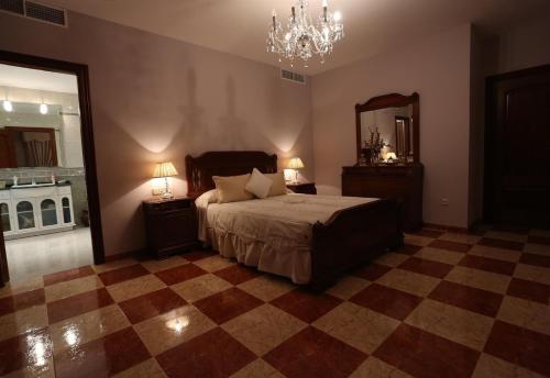 1 dormitorio con cama, espejo y lámpara de araña en Casa Montes Del Castillo, en Almuñécar