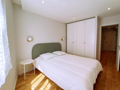 - une chambre avec un grand lit blanc et une tête de lit verte dans l'établissement Viva Riviera Palais Holiday Design 2 Bedrooms, à Cannes