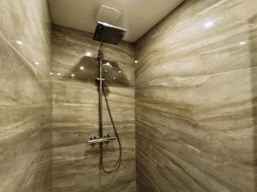 eine Dusche im Bad mit einer Steinmauer in der Unterkunft Viva Riviera Palais Holiday Design 2 Bedrooms in Cannes