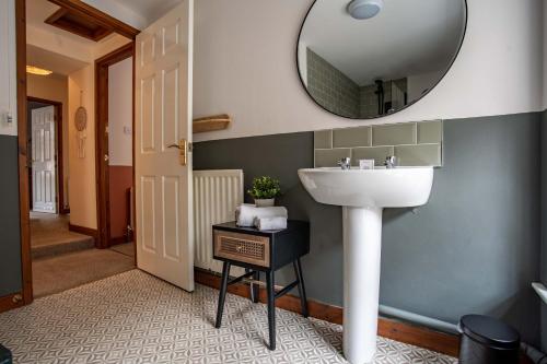 baño con lavabo y espejo en la pared en The Bottles Lodge, en Alnwick