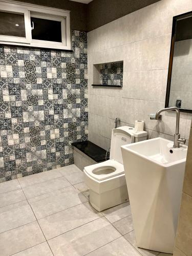 a bathroom with a toilet and a sink at 12th Avenue in Lahore