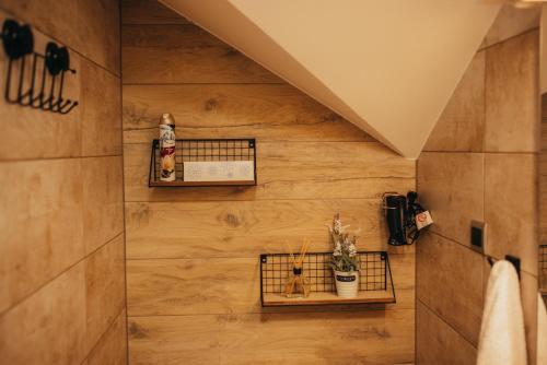a bathroom with wooden walls and shelves with plants at Villa Magnolia in Sveti Martin na Muri