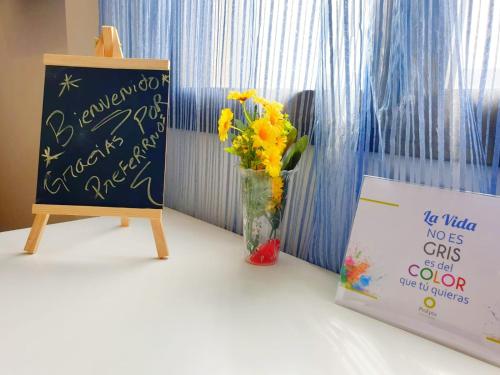 a sign and a vase with flowers next to a sign at Hotel M5 Valencia Aeropuerto in Manises