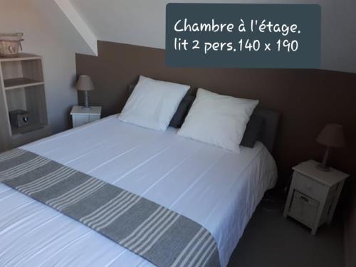a bedroom with a large bed with two pillows at Résidence La Naturelle in Wimereux