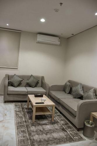 a living room with two couches and a coffee table at Doolv Hotel Apartments in Hail