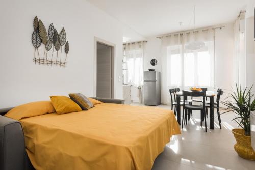 Civico40 Luminoso appartamento con balconi e garage privato في فيرونا: غرفة نوم عليها سرير مع بطانية صفراء