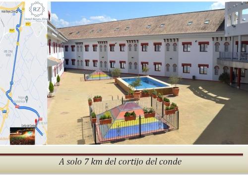 a large building with a swimming pool in a courtyard at Hotel Reyes Ziries in Albolote