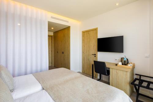 a bedroom with a bed and a desk with a television at AP Cabanas Beach & Nature - Adults Friendly in Cabanas de Tavira