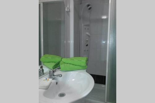 a bathroom with a sink and a green towel at CANGAS DE ONIS LUCY in Cangas de Onís
