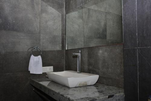 un bagno con lavandino bianco su un bancone di Ritz Heritage a Lonavala