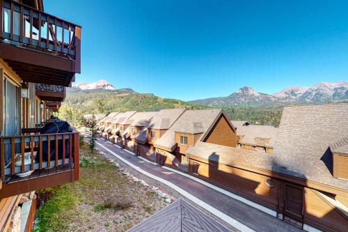 a row of wooden buildings with mountains in the background at Cascade #54 in Durango