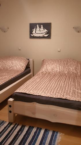two beds sitting next to each other in a bedroom at Tähe Holiday Home in Pärnu