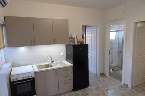 a kitchen with a sink and a black refrigerator at Harmony House Marathopoli 2 in Marathopoli
