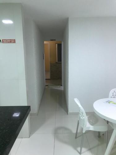 a white room with a table and a chair at Pousada Green Aeroporto Rodoviária in Fortaleza