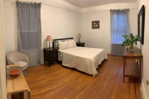 a bedroom with a bed and a wooden floor at Cozy 2 bedroom apartment in Queens in Jackson Heights