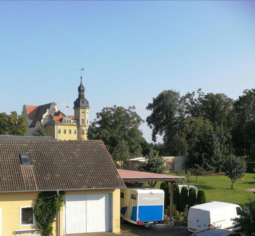 a rv parked in front of a building with a tower at Pension Schlossblick Thallwitz in Thallwitz