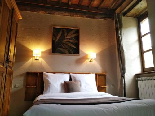 a bedroom with a bed with two lights on the wall at Auberge Cevenole in Valleraugue