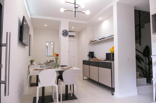 a kitchen with white walls and a table and chairs at B&B Toci in Volla