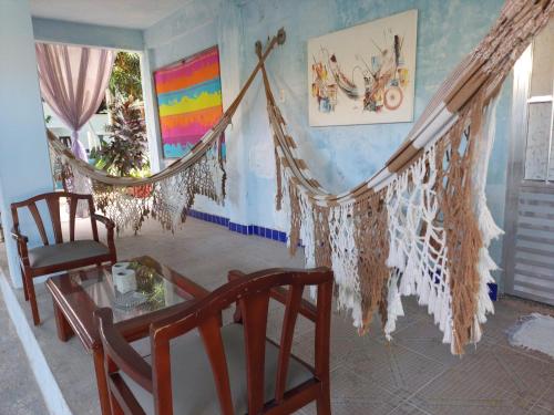 a living room with a hammock and a table and chairs at Pousada Azul in Canoa Quebrada