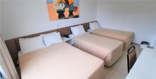 Habitación con 2 camas y una foto en la pared. en Simas Praia Hotel, en Aracaju