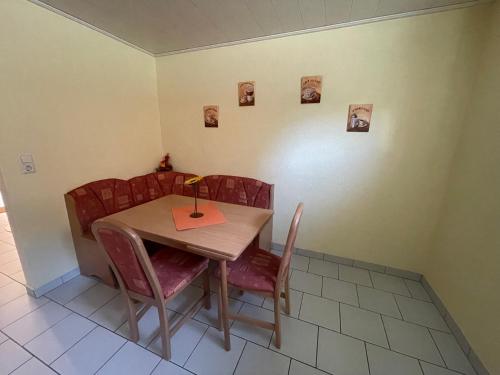 einen Tisch und Stühle mit Tisch und Bildern an der Wand in der Unterkunft Haus Alexandra in Rust