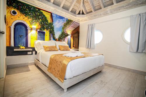 1 dormitorio con 1 cama con una pintura en la pared en Hotel Boutique Callecitas de San Diego en Cartagena de Indias