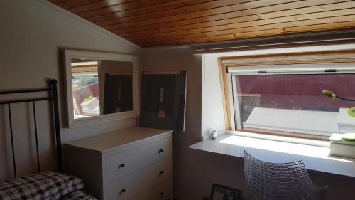 a small bedroom with a window and a dresser and a bed at Atico Playa Fontaiña in Vigo