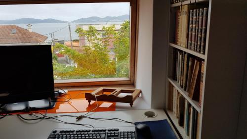 a computer sitting on a desk next to a window at Atico Playa Fontaiña in Vigo