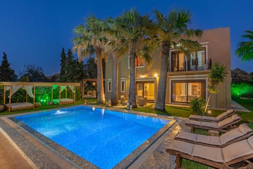 a home with a swimming pool and palm trees at Luxury Mansion Rhodes in Ialysos