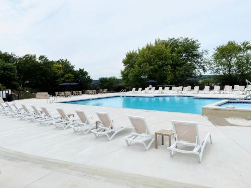a row of white chairs and a swimming pool at The Ridge Hotel in Lake Geneva