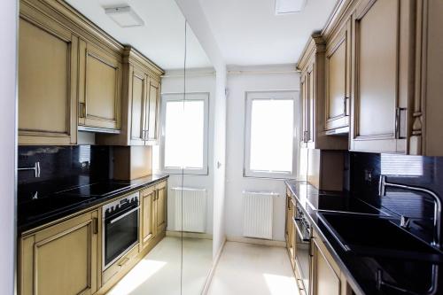 a kitchen with wooden cabinets and black counter tops at Apartament Amaya in Bistriţa