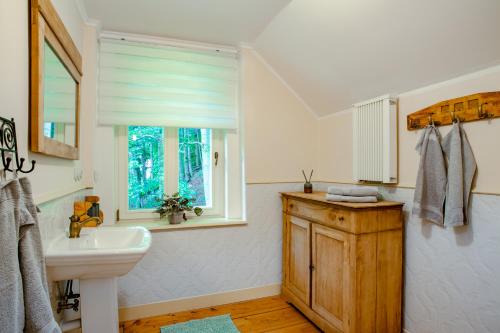 baño blanco con lavabo y ventana en Vila Weigend en Libouchec