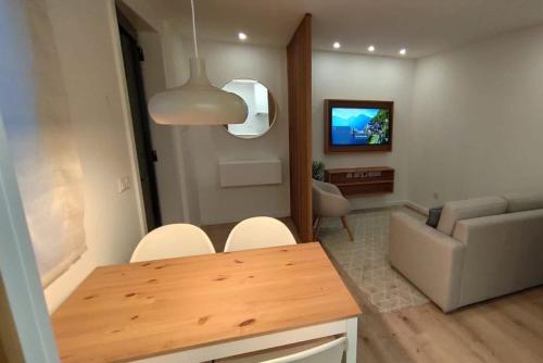 a living room with a table and a couch at Green Garden Houses in Chaves