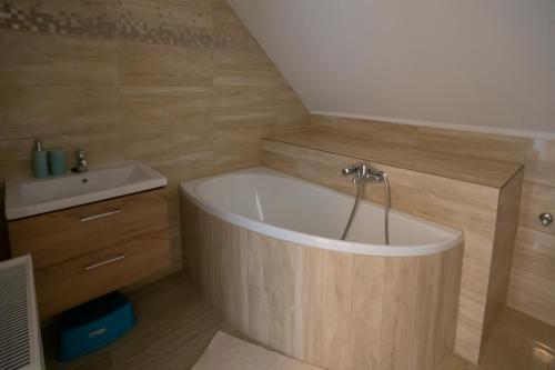 een badkamer met een bad en een wastafel bij Égerliget Vendégház in Harkány