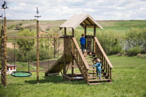 un homme et un enfant sur une structure de jeu en bois dans l'établissement Садиба "Банька у джерела", à Salikha