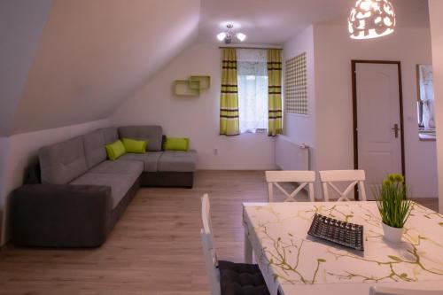 a living room with a couch and a table at Égerliget Vendégház in Harkány