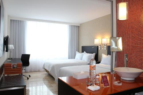 een hotelkamer met een bed en een wastafel bij Fiesta Inn Chetumal in Chetumal