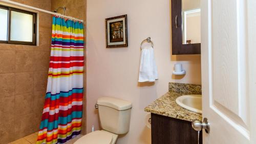 y baño con cortina de ducha colorida y aseo. en 2-Bedroom, 2-Bath Condo Near Beach, en Coco