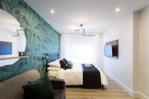 a bedroom with a bed and a couch at Blue Tropics Studio in Little Italy with kitchen by Den Stays in Montréal