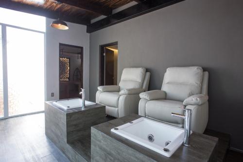 テキスキアパンにあるSaint George Hotel - Spa & Temazcalのバスルーム(椅子2脚、シンク、ソファ付)