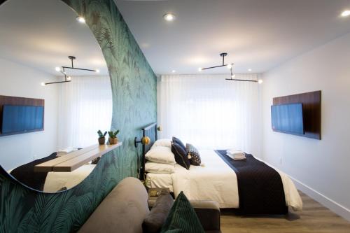 a bedroom with a bed and a desk and a couch at Sunny Green Palms Micro Studio with Yard View by Den Stays in Montréal