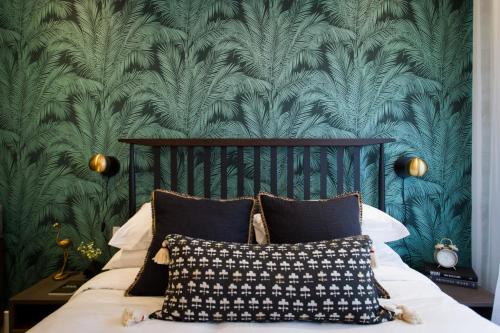 - une chambre avec un lit et du papier peint vert dans l'établissement Sunny Green Palms Micro Studio with Yard View by Den Stays, à Montréal