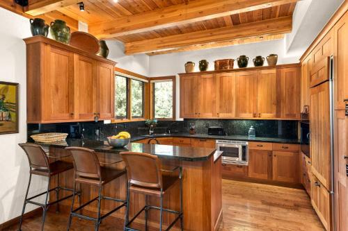 a kitchen with wooden cabinets and a island with bar stools at Ridge 27 in Snowmass Village