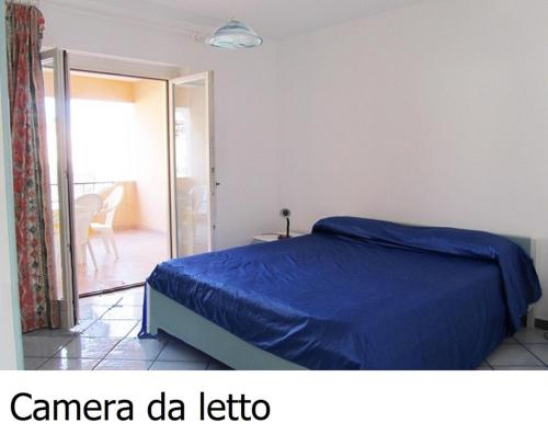 een slaapkamer met een bed met een blauw dekbed bij Appartamento a pochi passi dal mare in Canneto