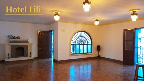 an empty room with a fireplace and a window at Hotel Lili - Popayán in Popayan